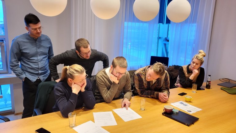 Samninganefnd BÍ gaumgæfir samningana fyrir undirritun.  
Mynd/AA